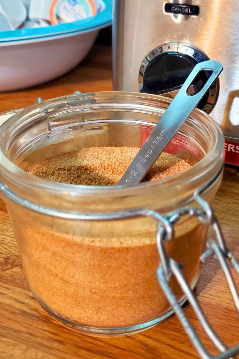 The best cinnamon sugar in an air tight container next to a toaster.