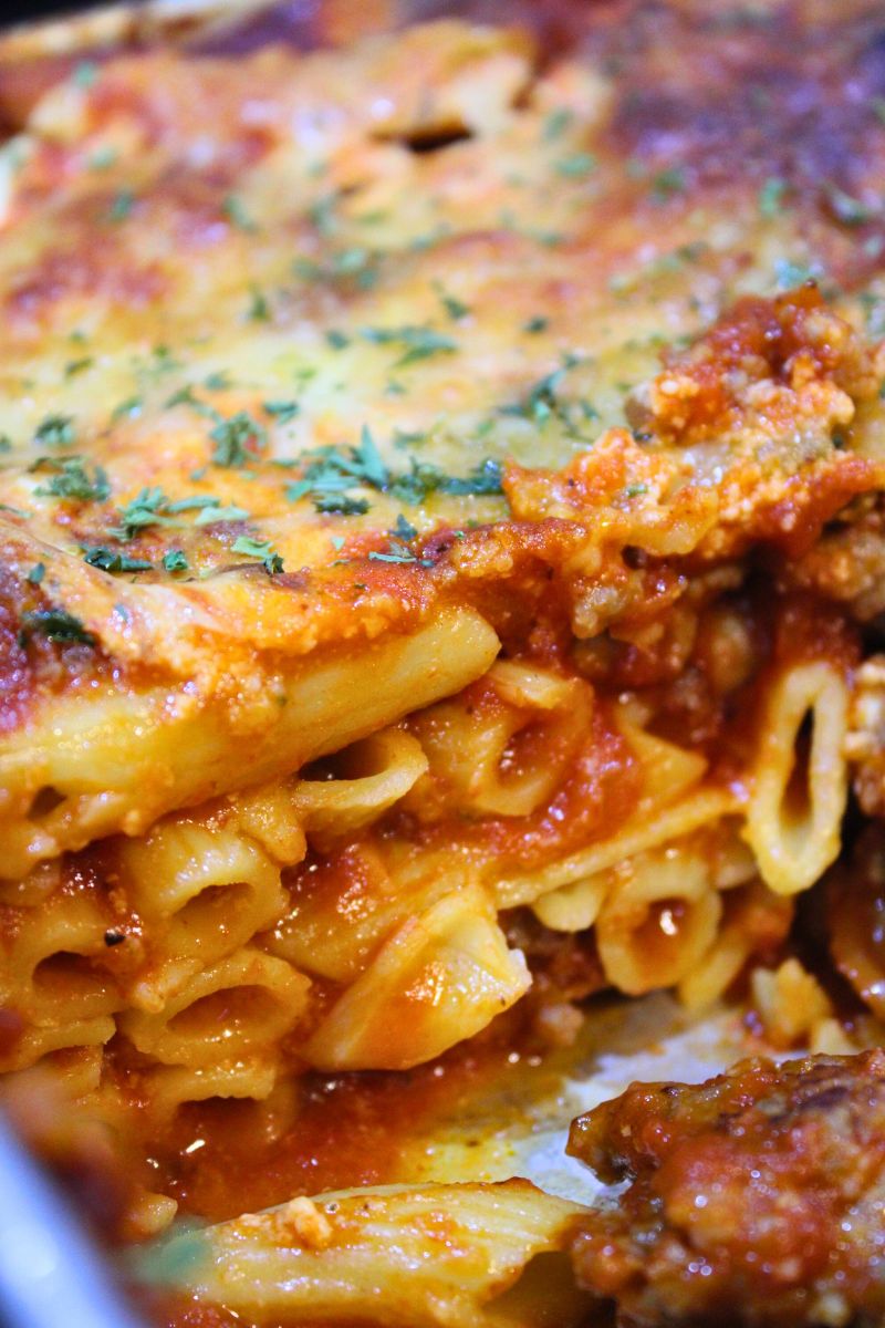 Baked high protein Italian sausage penne pasta layered with rich marinara sauce, creamy cheese, and fresh herbs – hearty homemade casserole recipe from Santa Rosa Homestead.