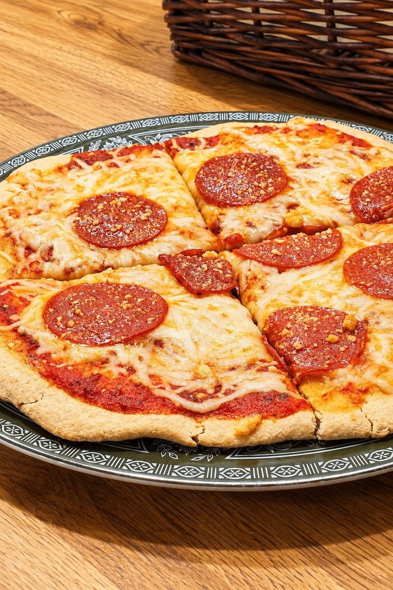 Homemade pepperoni pizza on a patterned plate, made with a no-yeast fresh-milled flour crust.